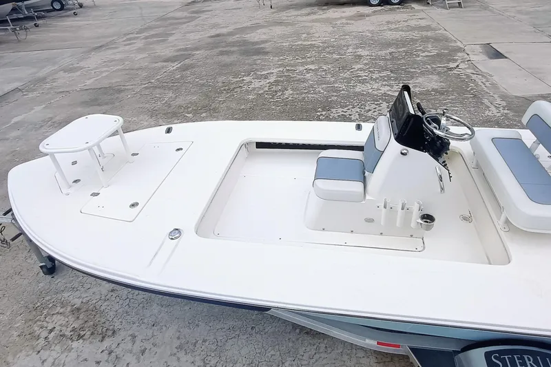 Slide: The Image of 2023 Sterling 180TS boat with white deck and seating, parked on concrete surface. - 22