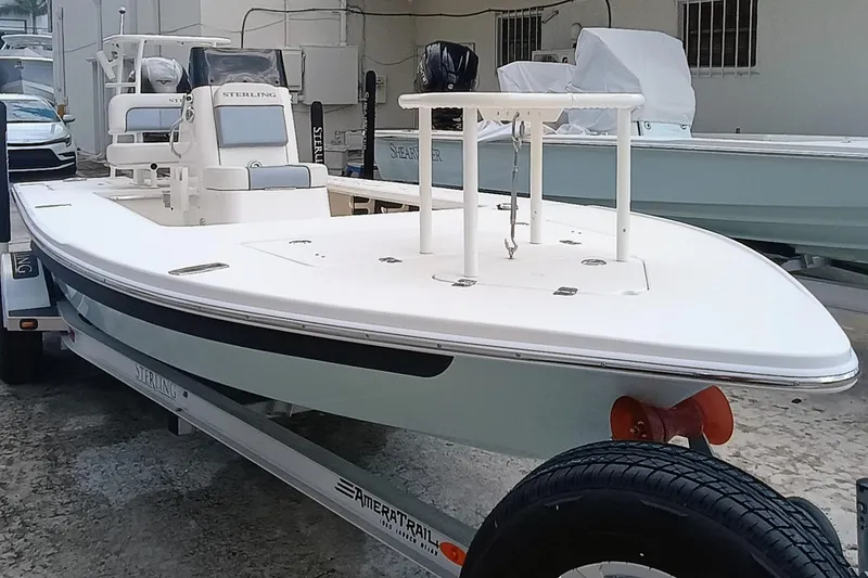 Slide: The Image of 2023 Sterling 180TS boat on trailer, sleek design, white exterior, parked outdoors. - 25
