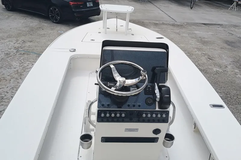 Slide: The Image of 2023 Sterling 180TS boat interior with steering console, docked on concrete surface. - 6