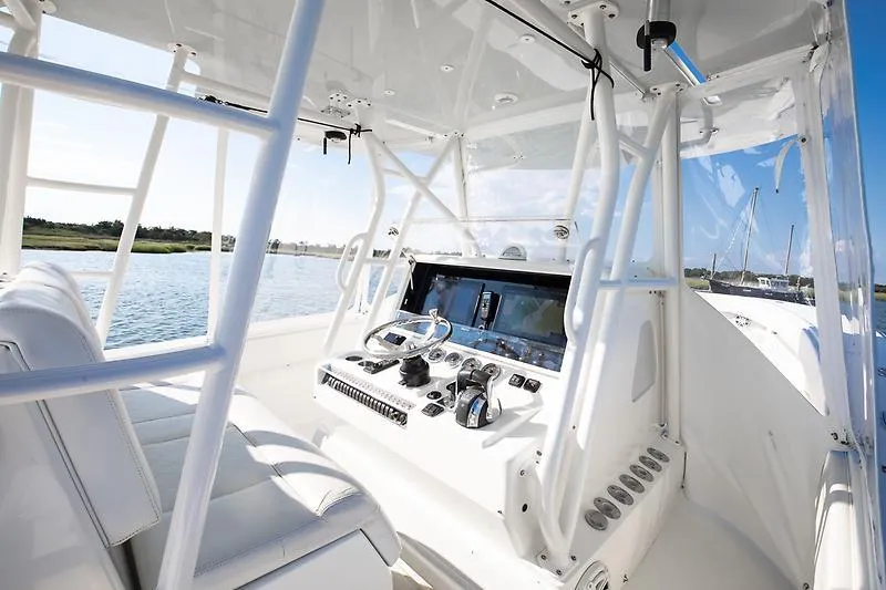 Slide: The Image of 2017 SeaVee 390OZ boat cockpit with modern controls and seating, overlooking calm waters. - 8