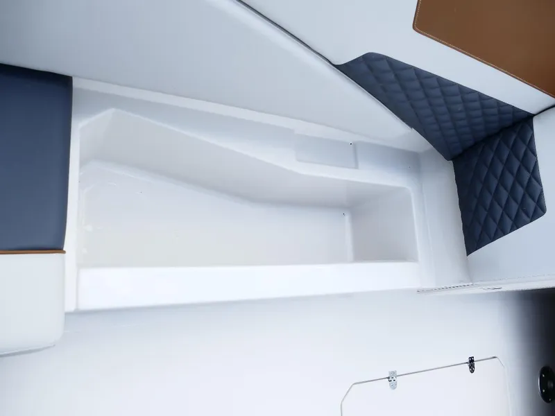 Slide: The Image of Interior view of 2026 Starcraft SVX 231 OB boat with cushioned seating and storage area. - 18