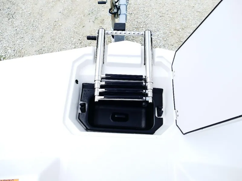 Slide: The Image of 2026 Starcraft SVX 231 OB boat ladder compartment, open hatch, and metal steps. - 28