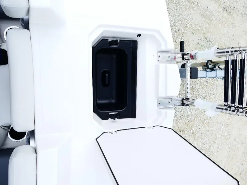 Slide: The Image of 2026 Starcraft SVX 231 OB boat with open storage compartment and ladder. - 29