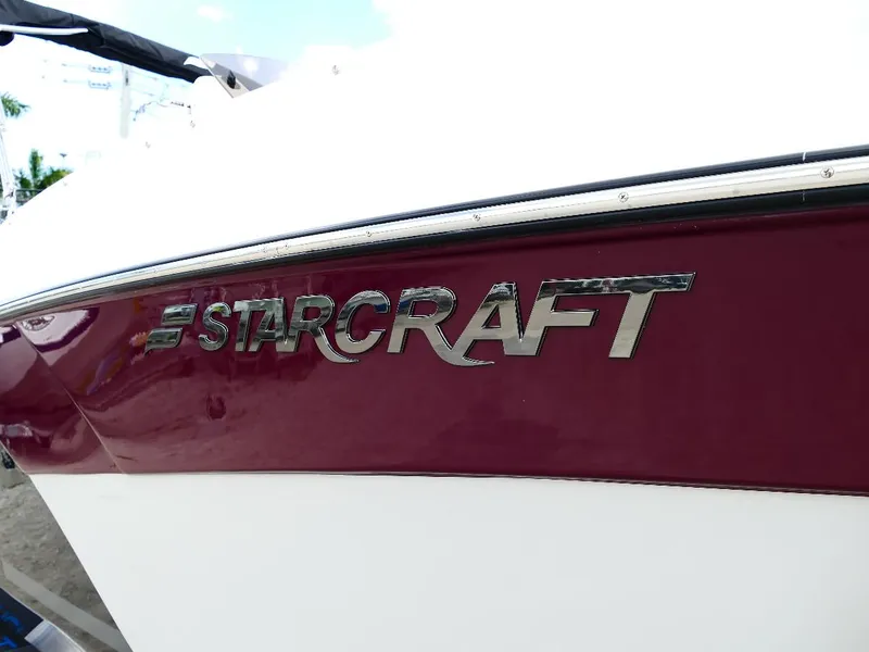 Slide: The Image of 2026 Starcraft SVX 231 OB boat logo on maroon and white hull. - 3