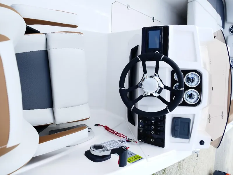 Slide: The Image of 2026 Starcraft SVX 231 OB boat dashboard with steering wheel and controls. - 45