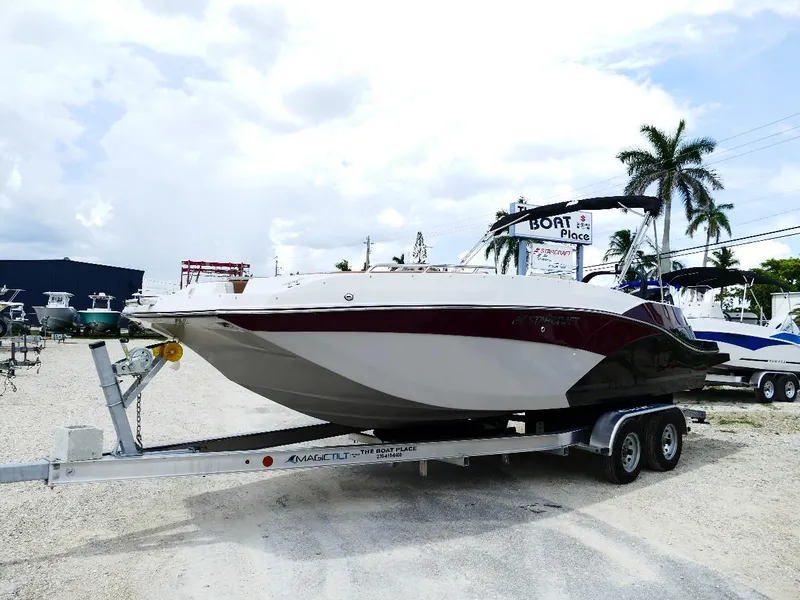 Slide: The Image of 2026 Starcraft SVX 231 OB boat on trailer at dealership, palm trees in background. - 7