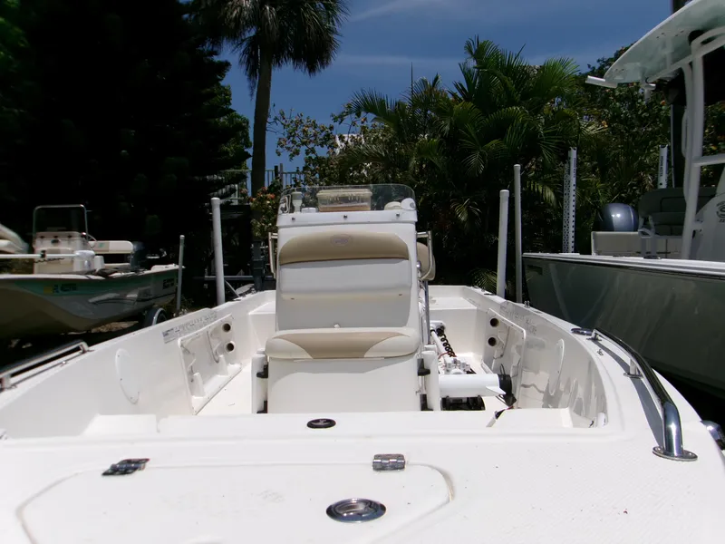 Slide: The Image of 2016 Key West 1720 Center Console boat with seating, surrounded by lush greenery. - 2