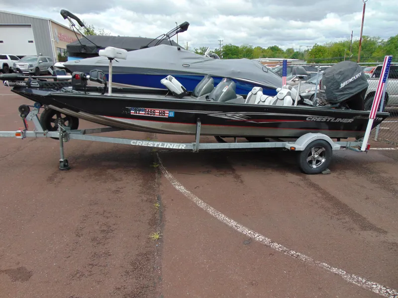 Slide: The Image of 2014 Crestliner VT 19 fishing boat on trailer, parked outdoors. - 2