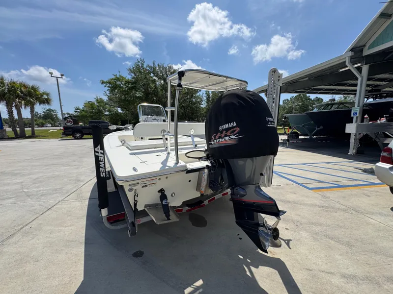 Slide: The Image of 2021 Hewes Redfisher 18 boat with Yamaha engine, parked outdoors under a clear sky. - 17