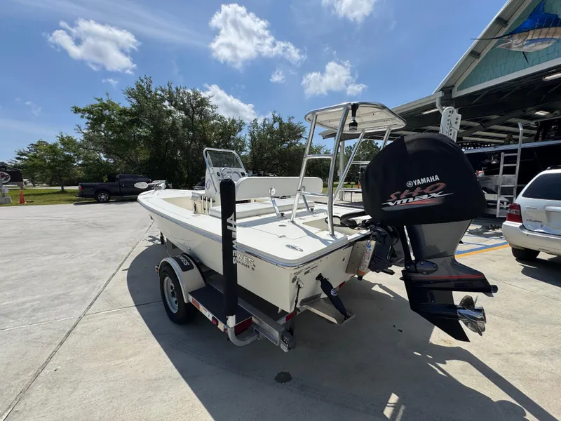 Slide: The Image of 2021 Hewes Redfisher 18 boat on trailer with Yamaha outboard motor, parked outdoors. - 18