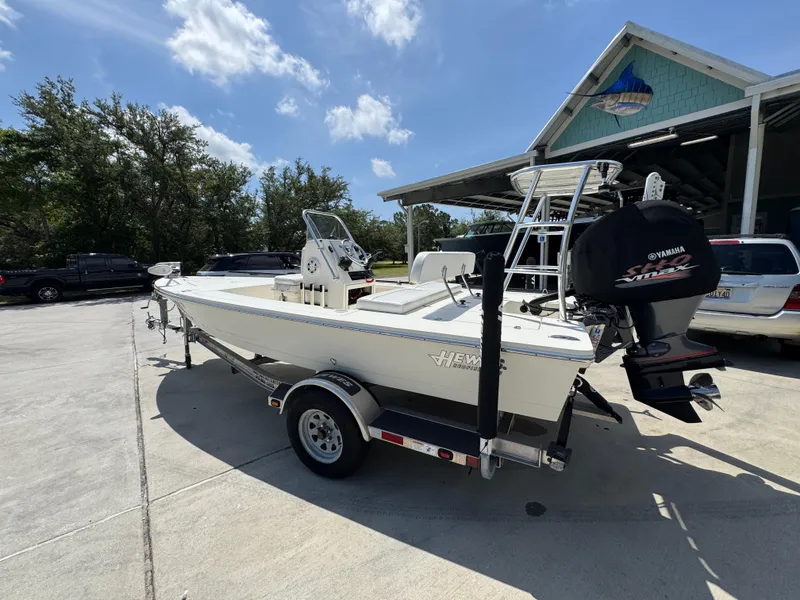 Slide: The Image of 2021 Hewes Redfisher 18 boat on trailer, parked outdoors under a sunny sky. - 19