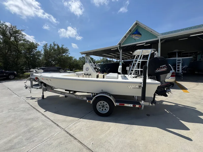 Slide: The Image of 2021 Hewes Redfisher 18 boat on trailer, parked outdoors under clear blue sky. - 20