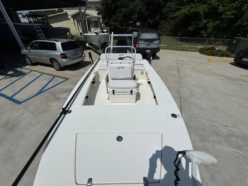 Slide: The Image of 2021 Hewes Redfisher 18 boat parked in a lot, surrounded by vehicles. - 26