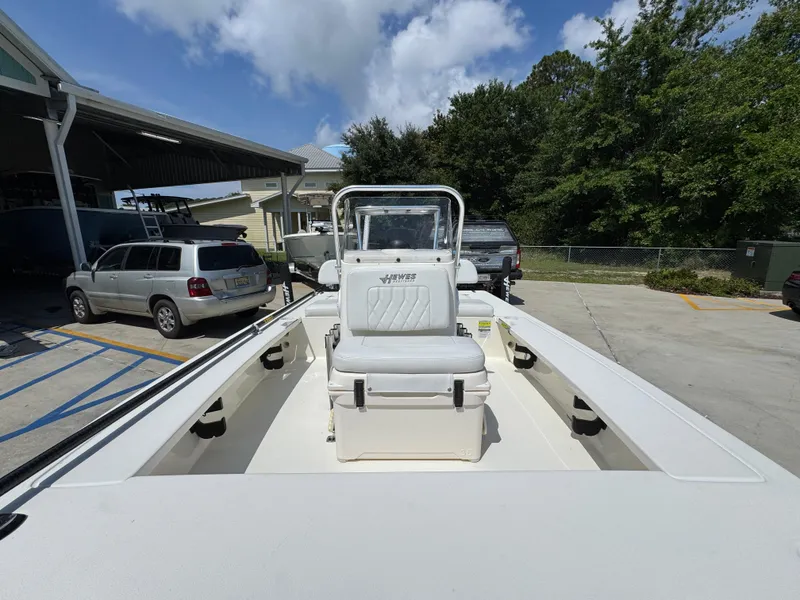 Slide: The Image of 2021 Hewes Redfisher 18 boat with center console, parked outdoors under clear skies. - 27