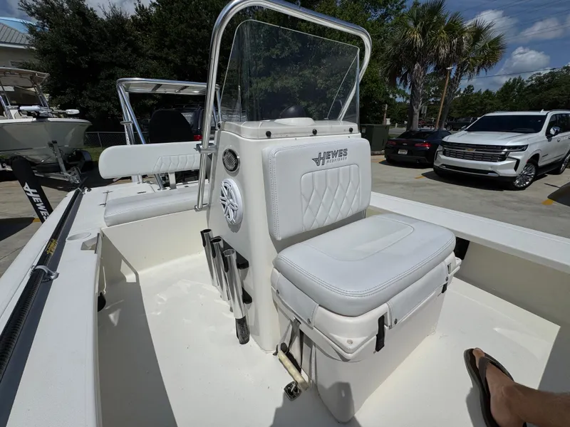 Slide: The Image of 2021 Hewes Redfisher 18 boat with white seating and console, parked outdoors. - 29