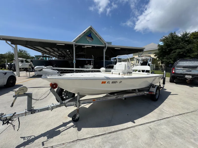 Slide: The Image of 2021 Hewes Redfisher 18 boat on trailer, parked outdoors under a sunny sky. - 3