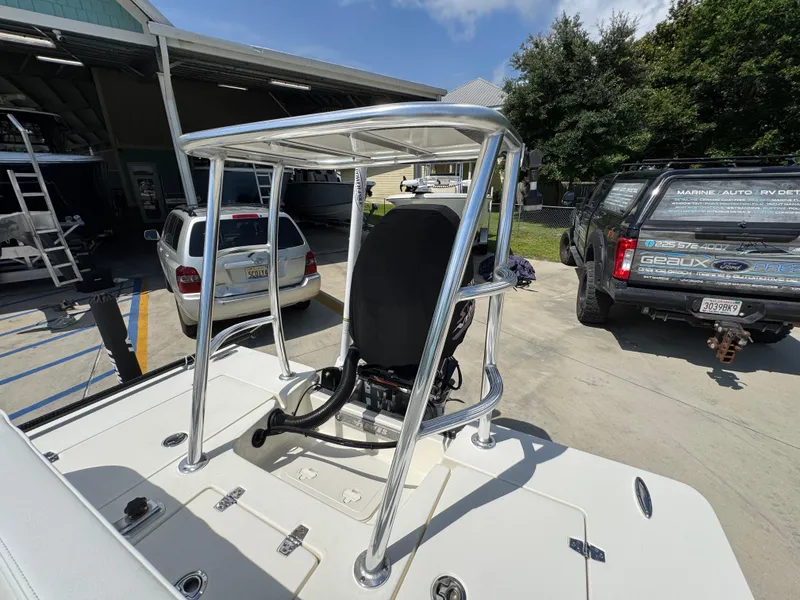 Slide: The Image of 2021 Hewes Redfisher 18 boat with T-top, parked outdoors near vehicles. - 37