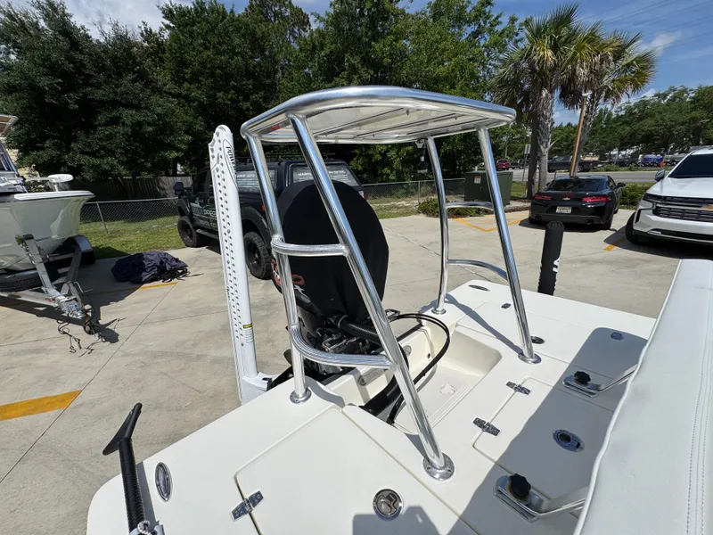 Slide: The Image of 2021 Hewes Redfisher 18 boat with T-top and motor, parked outdoors. - 38