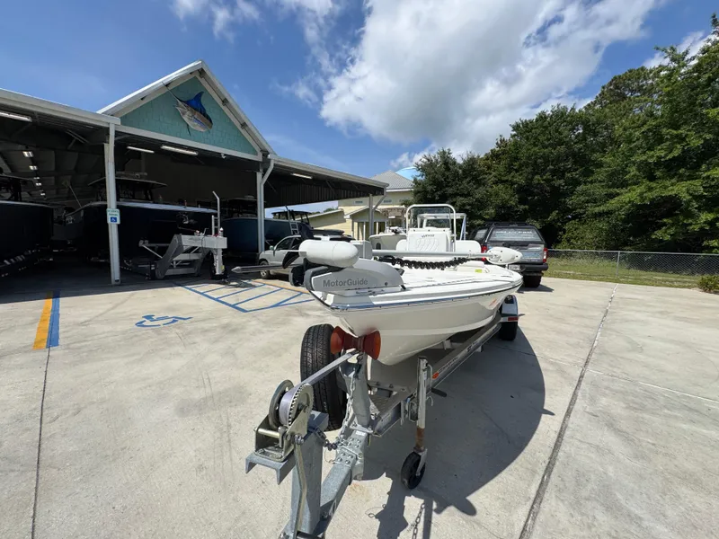 Slide: The Image of 2021 Hewes Redfisher 18 boat on trailer, parked outside a storage facility under a clear sky. - 5