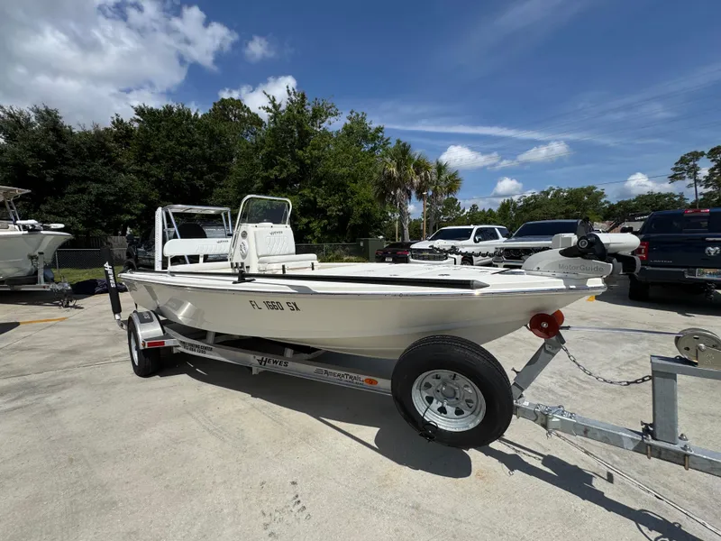 Slide: The Image of 2021 Hewes Redfisher 18 boat on trailer, parked outdoors under a clear blue sky. - 8