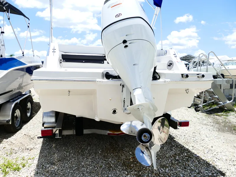 Slide: The Image of 2026 Starcraft SVX 231 OB DH boat with outboard motor, parked on gravel. - 13