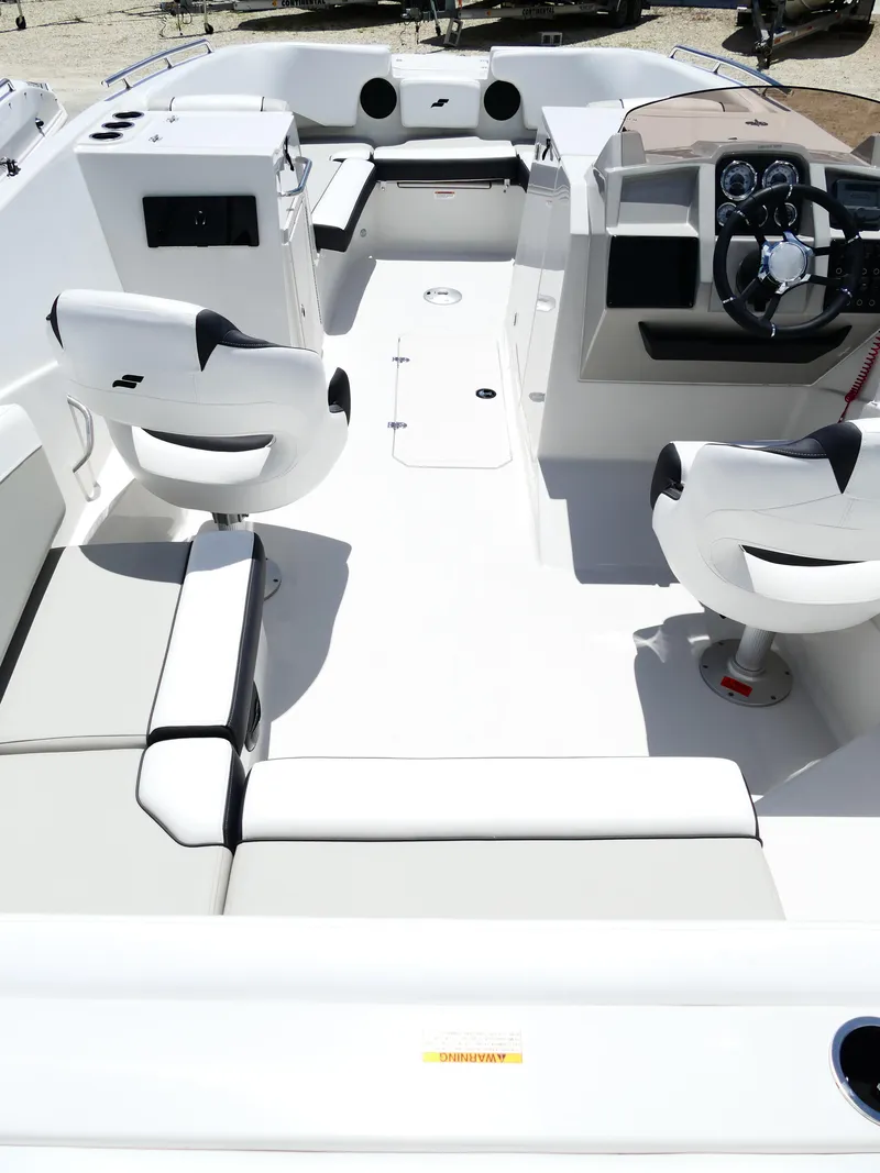 Slide: The Image of 2026 Starcraft SVX 231 OB DH boat interior with modern seating and steering console. - 15