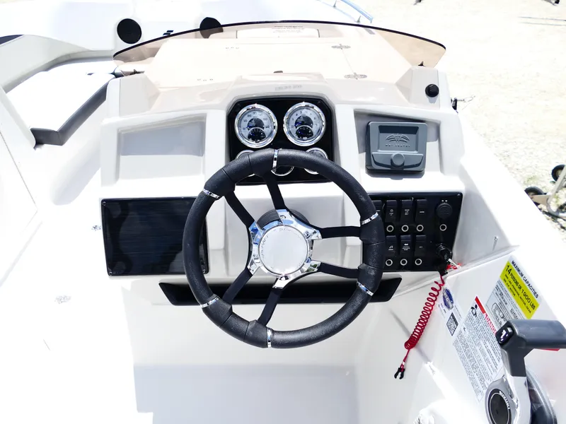 Slide: The Image of 2026 Starcraft SVX 231 OB DH boat dashboard with steering wheel and control panel. - 17