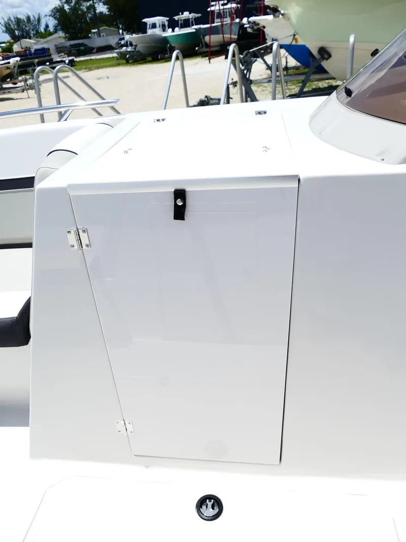 Slide: The Image of 2026 Starcraft SVX 231 OB DH boat compartment with sleek white finish and secure latch. - 24