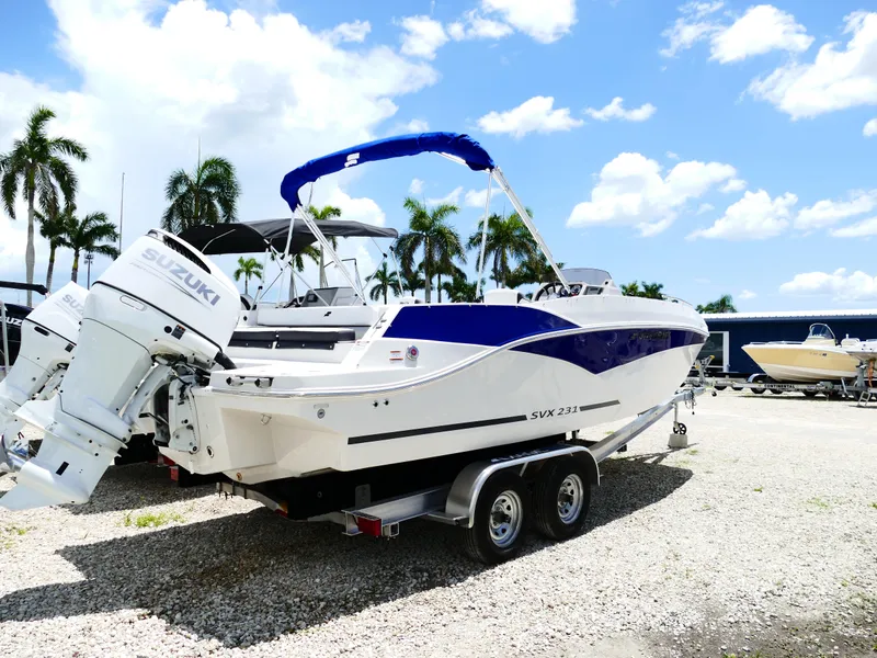 Slide: The Image of 2026 Starcraft SVX 231 OB DH boat with Suzuki engine on trailer, parked outdoors. - 9