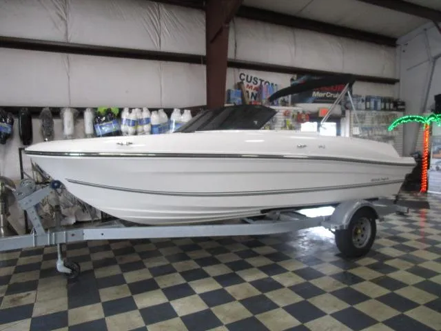 Slide: The Image of 2021 Bayliner VR4 Bowrider I/O on trailer in showroom with checkered floor. - 1