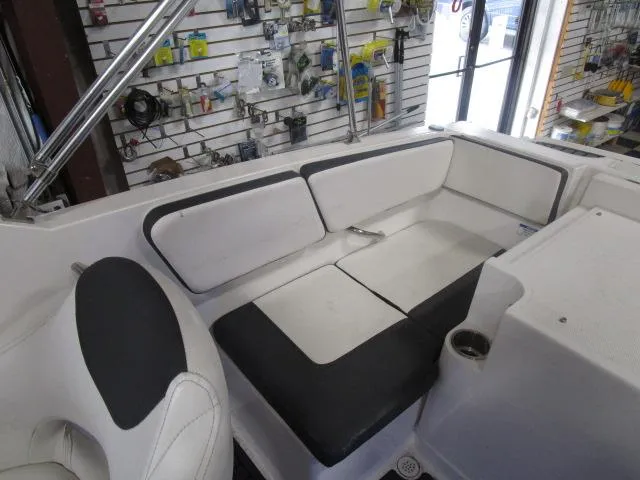 Slide: The Image of 2021 Bayliner VR4 Bowrider I/O interior with white and black seating in a showroom. - 10