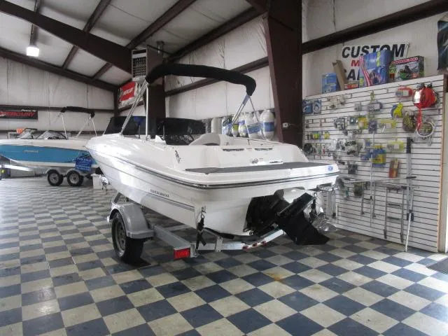 Slide: The Image of 2021 Bayliner VR4 Bowrider I/O in showroom, on trailer, with accessories displayed. - 2