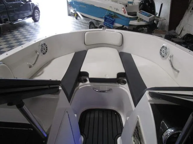 Slide: The Image of 2021 Bayliner VR4 Bowrider I/O interior with seating and speakers in a showroom. - 6