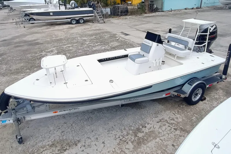 Slide: The Image of 2023 Sterling 180TS boat on trailer, white and blue design, parked outdoors. - 1