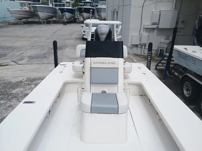 Slide: The Image of 2023 Sterling 180TS boat with sleek design, docked in a marina. - 13