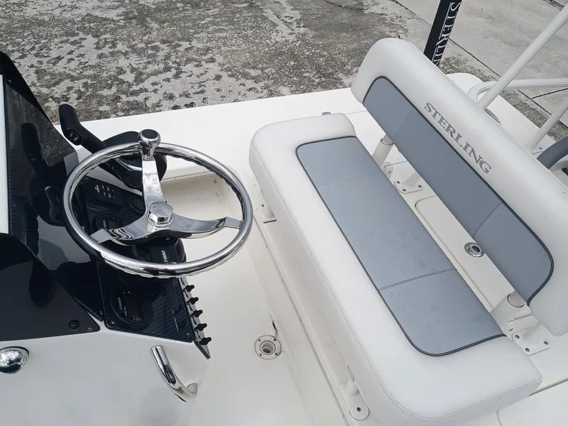 Slide: The Image of 2023 Sterling 180TS boat interior with steering wheel and cushioned seating. - 7