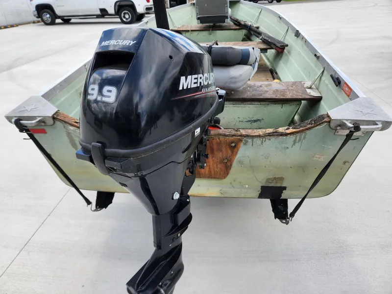 Slide: The Image of 1970 Starcraft Aluminum boat with Mercury 9.9 outboard motor, parked on concrete. - 3