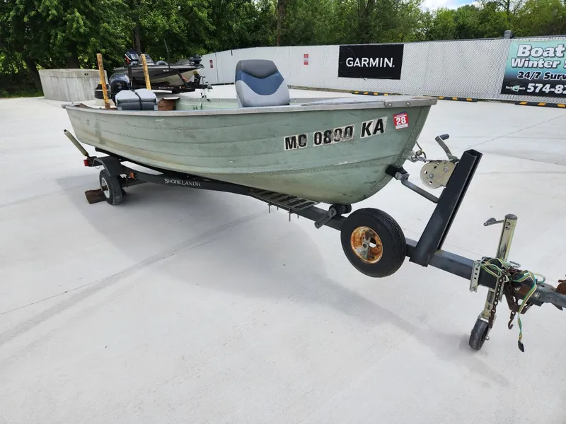 Slide: The Image of 1970 Starcraft Aluminum boat on trailer, parked outdoors with visible registration number. - 5