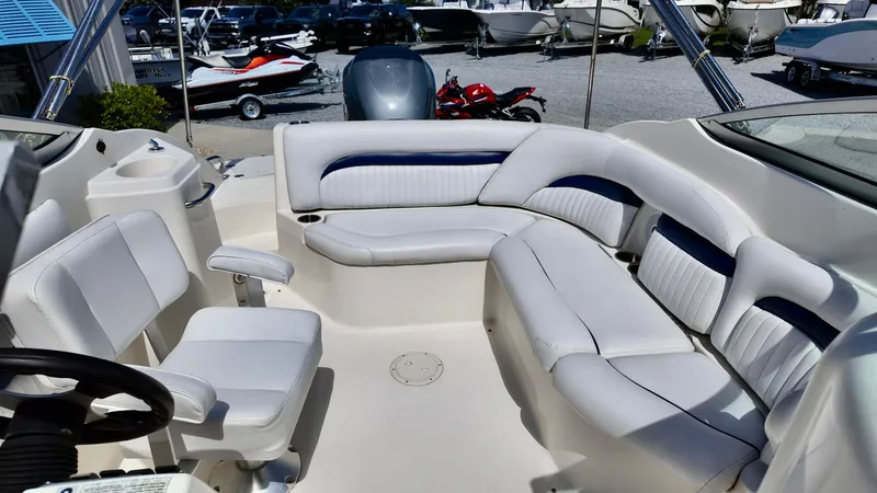 Slide: The Image of 2008 Hurricane 220 Sun Deck boat interior with white seating and steering wheel. - 10