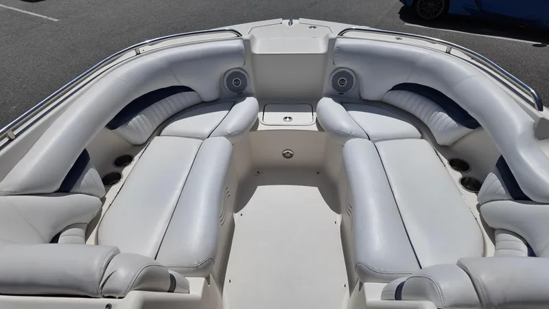 Slide: The Image of 2008 Hurricane 220 Sun Deck boat interior with white seating and speakers. - 12