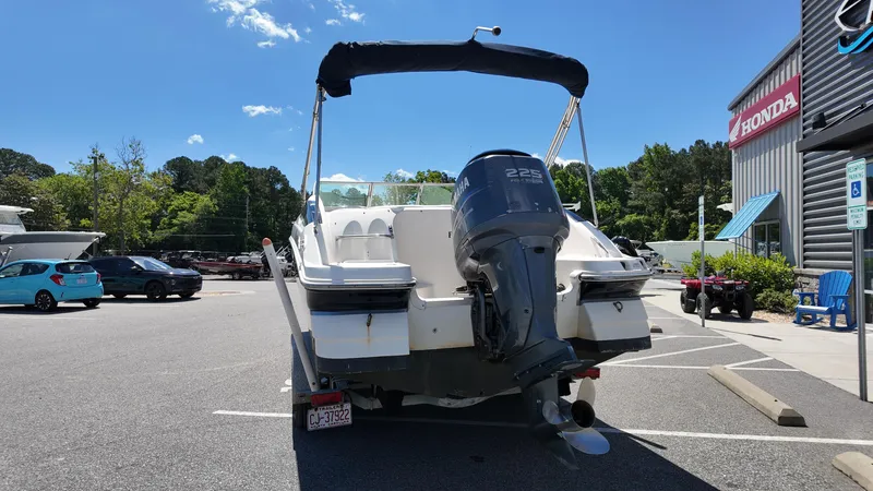 Slide: The Image of 2008 Hurricane 220 Sun Deck boat with outboard motor in parking lot. - 2