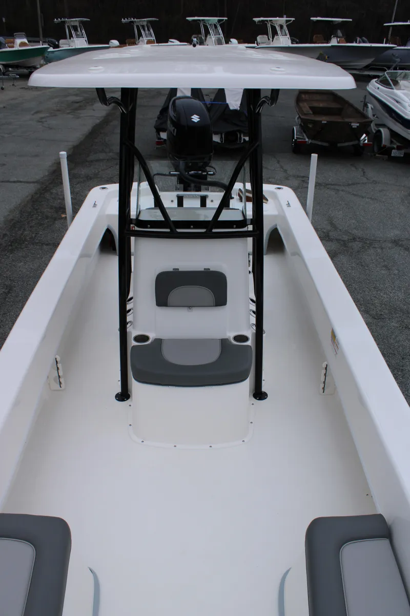 Slide: The Image of 2025 Sundance B22CCR boat with T-top and seating, displayed in a marina setting. - 10
