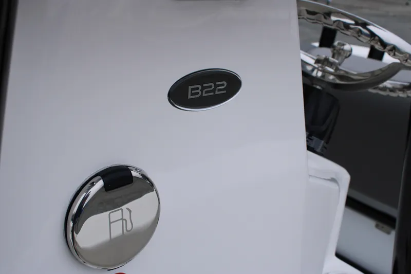 Slide: The Image of 2025 Sundance B22CCR boat dashboard with fuel cap and model emblem. - 21