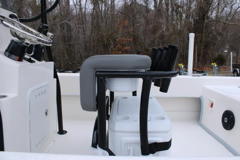 Slide: The Image of 2025 Sundance B22CCR boat interior with seating and storage, surrounded by trees. - 24
