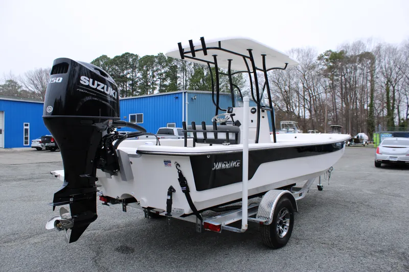 Slide: The Image of 2025 Sundance B22CCR boat with Suzuki engine on trailer, parked outdoors. - 4