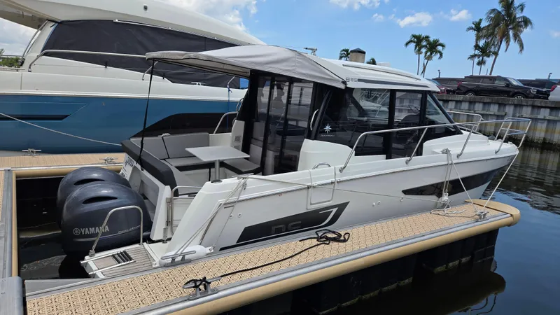 Slide: The Image of 2019 Jeanneau NC895 boat docked, featuring twin Yamaha engines and a sleek design. - 0