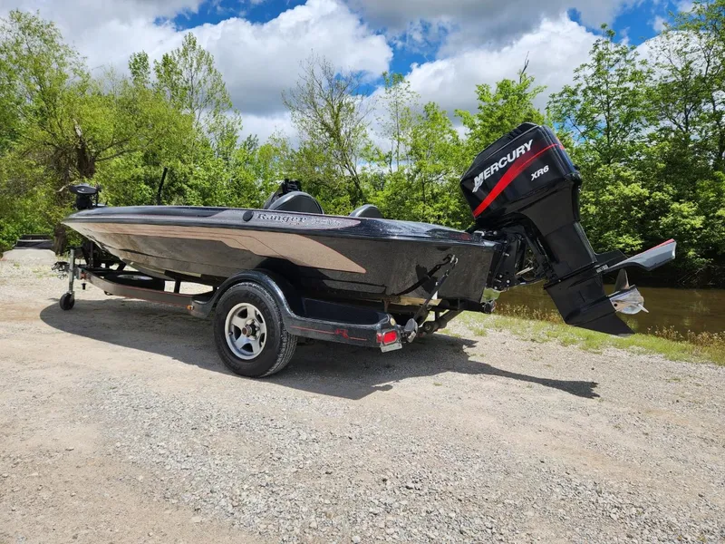 Slide: The Image of 2002 Ranger 185VS boat with Mercury engine on a trailer, parked outdoors. - 2