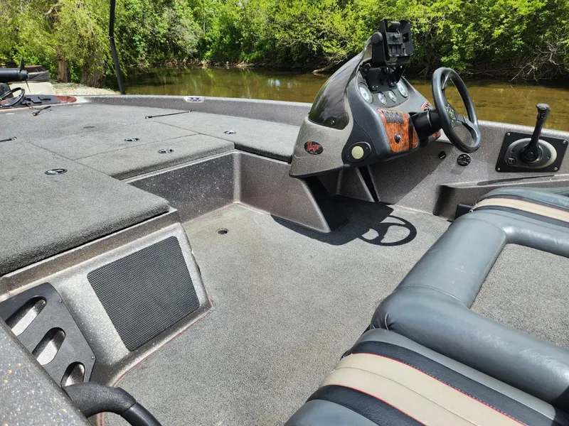 Slide: The Image of 2002 Ranger 185VS boat interior with steering wheel, dashboard, and seating near a river. - 6