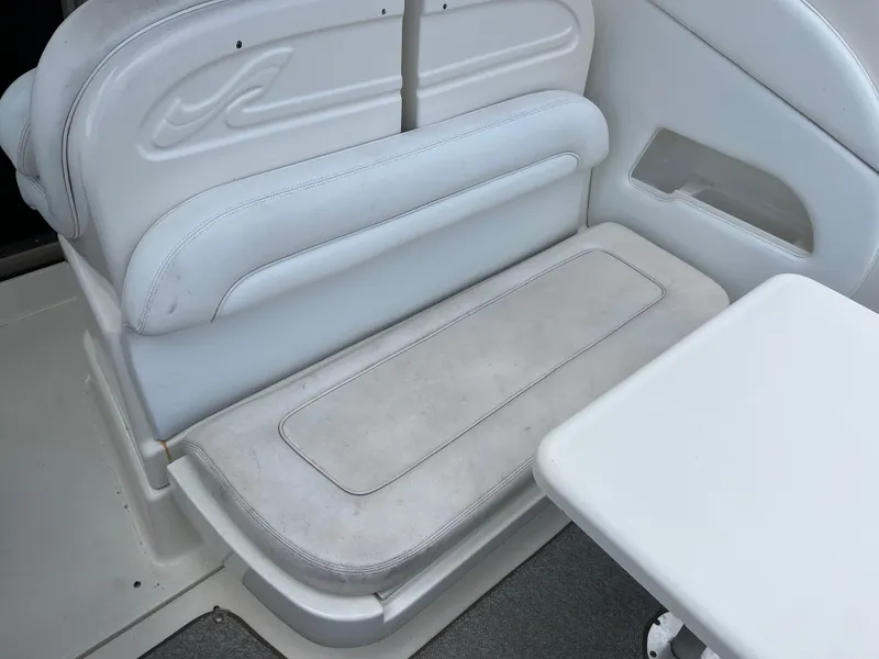 Slide: The Image of 2005 Sea Ray 300 Sundancer interior seating with white upholstery and table. - 12