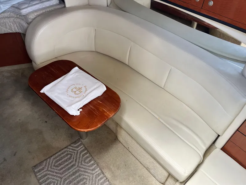 Slide: The Image of Interior of 2005 Sea Ray 300 Sundancer with beige leather seating and wooden table. - 15